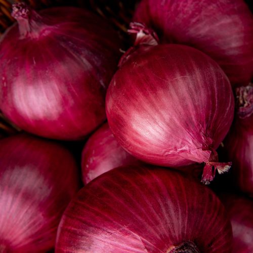 close up view of basket of red onions